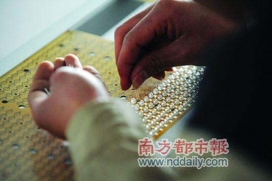 工人忙著安裝用于燈具發(fā)光的LED燈珠，這類工作處于LED燈具生產(chǎn)的最下游。資料圖